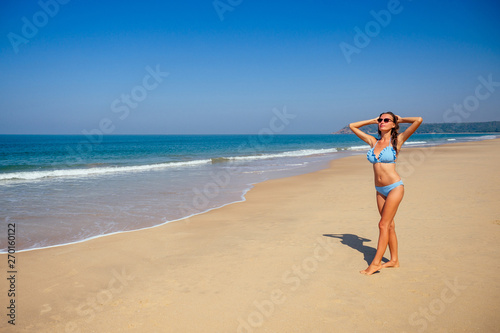 Wallpaper Mural Young female imodel n a stylish blue bikini swimsuit enjoying sunny day on tropical beach paradise hotel resort.freedom and independence woman concept.copespase foam wave spf sunscreen Torontodigital.ca
