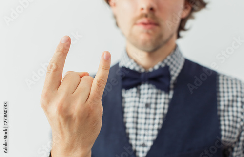 Man with beard in a bowtie with funny gesture