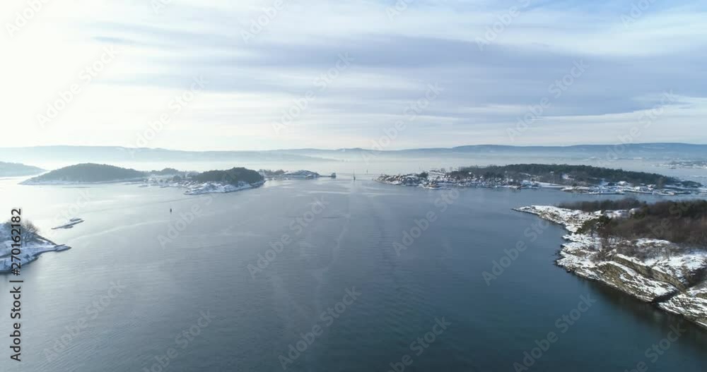 4K aerial with forward tilt motion of the Oslo fjord ocean with its islands and a sailboat in daylight. 4K aerial with forward tilt motion of the Oslo fjord ocean with its islands and a sailboat in daylight.