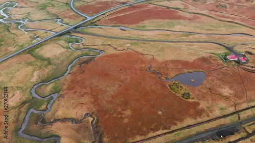 Aerial footage looking down at a river coming from Bjarnarfoss waterfall, Iceland. Also showing other rivers and a road. photo