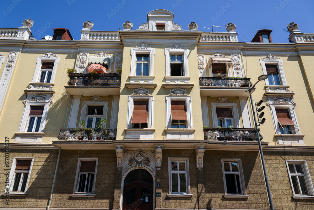Belgrade, Serbia - April 19, 2018. Living architecture building facade in old town central street close view with details. Apartment building with brown shutters in Belgrade's historical center. Belgrade, Serbia - April 19, 2018. Living architecture building facade in old town central street close view with details. Apartment building with brown shutters in Belgrade's historical center.