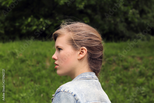 Portrait of a young woman model on a background of nature.