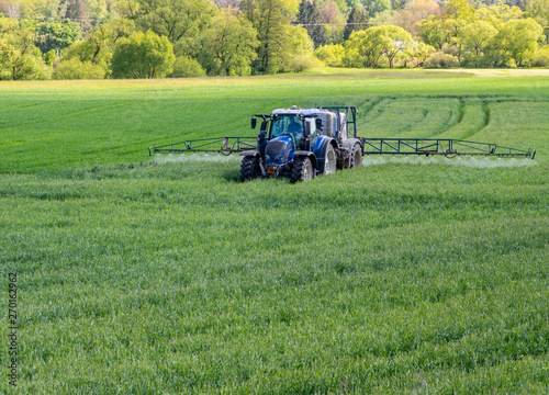 Traktor sprüh Schädlingsbekämpfungsmittel auf ein Feld photo