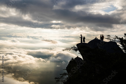 many cloud on sunrise with silhouette people on top of mountain