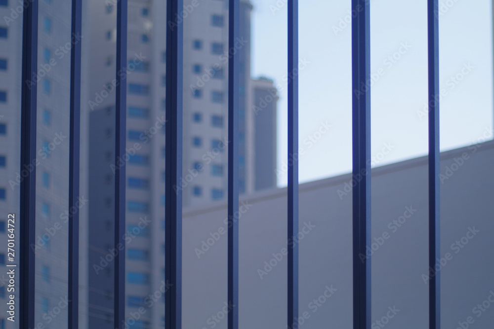 A building and blue sky behind a vertical structure. A building and blue sky behind a vertical structure.