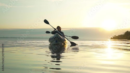 Young couple with kayak during sunset