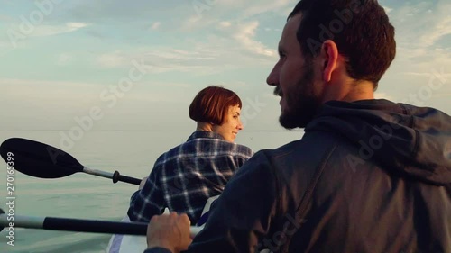 Young couple with kayak during sunset