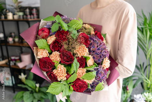 Large Beautiful bouquet of mixed flowers in woman hand. Floral shop concept . Beautiful fresh cut bouquet. Flowers delivery