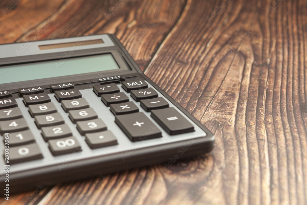 Modern calculator on a wooden table, business concept, close-up Modern calculator on a wooden table, business concept, close-up