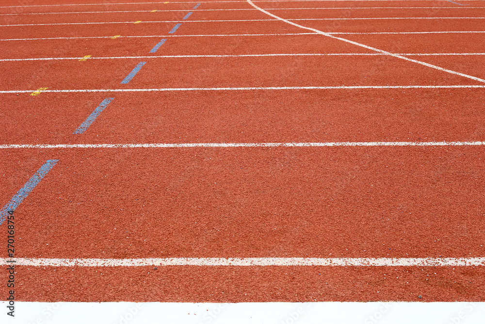 all-weather running track, rubberized artificial racing lane surface for track and field athletics, texture of white lines and curved in the stadium
