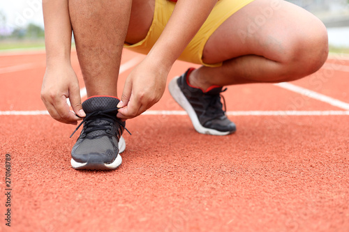 barefoot running shoes close up. male athlete tying laces shoelace for jogging on road concrete floor. Runner ties getting ready for training. Sport lifestyle.