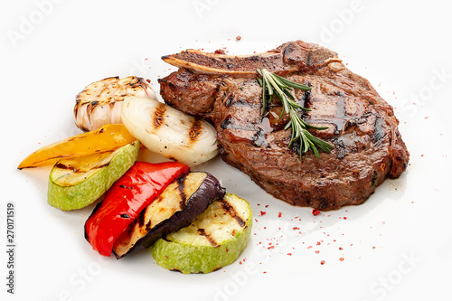 Veal bone steak with grilled vegetables on a white background