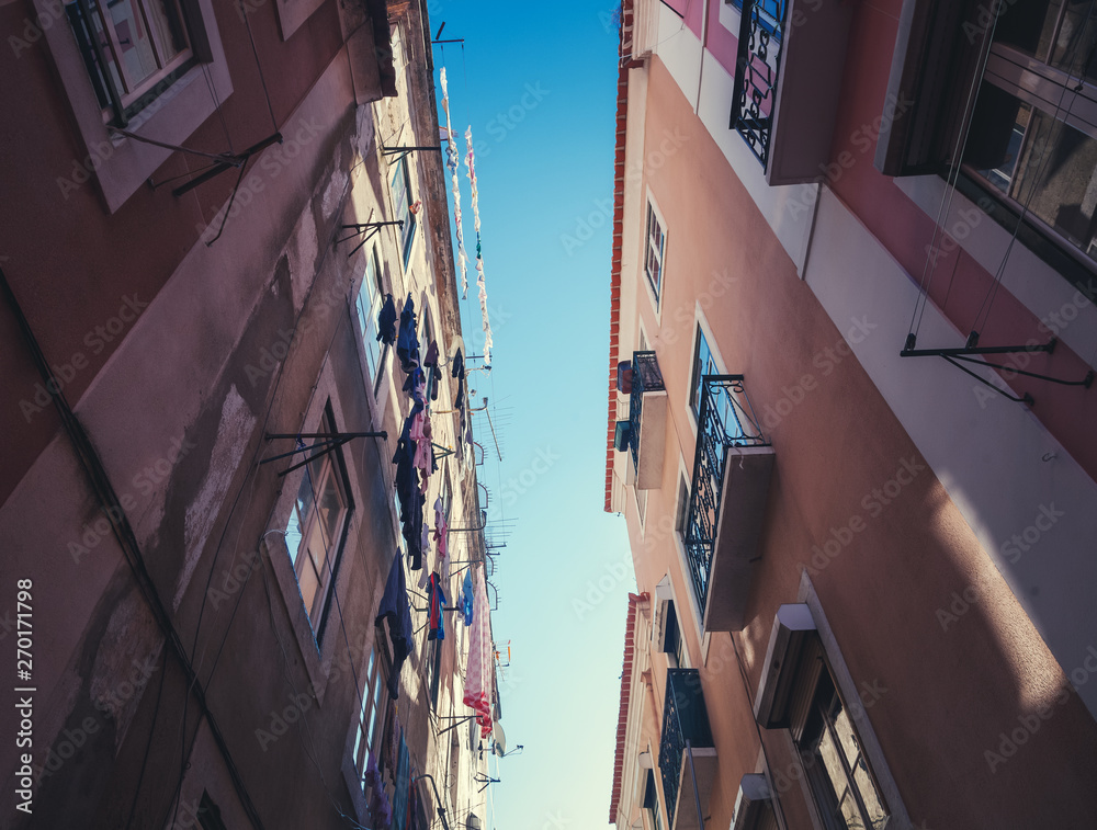 Φωτογραφία A narrow European street and sky, picture taken from below