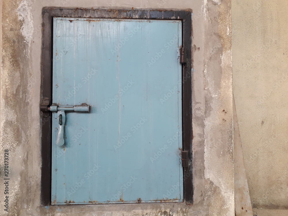 Small blue door Steel bolt lock On the cement floor