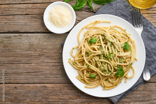 Pesto spaghetti pasta with basil, garlic, pine nuts, olive oil. Copy space. Rustic table