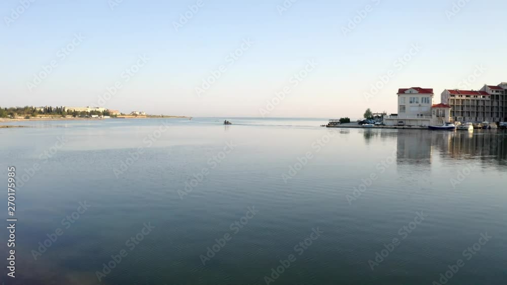 Aerial from a beach to a small boat leaving the Kruhla Bay in Sevastopol, Crimea, Russia, Ukraine Aerial from a beach to a small boat leaving the Kruhla Bay in Sevastopol, Crimea, Russia, Ukraine