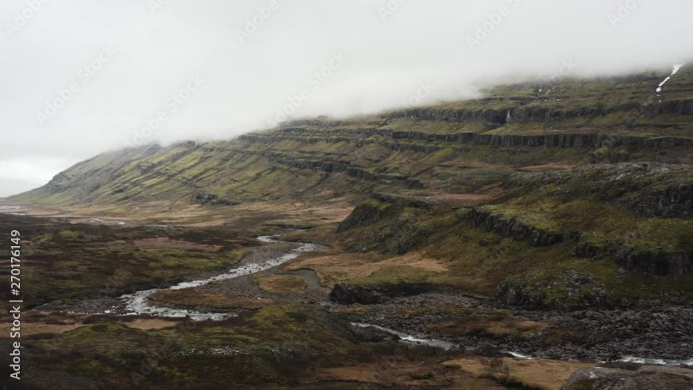 Panning view up in the moutain highlands of Iceland. Showing a river and a majestic waterfall. Folaldafoss Panning view up in the moutain highlands of Iceland. Showing a river and a majestic waterfall. Folaldafoss