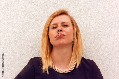 portrait of a sedutive blond woman with a cigarette in her lips photo