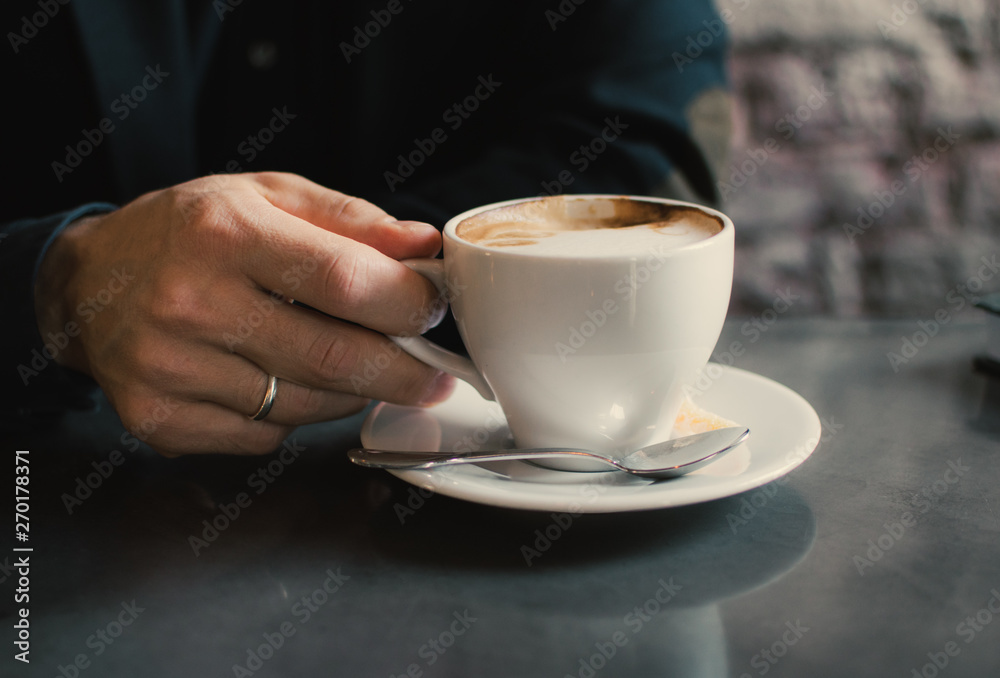Man holding a cup of cappuccino. Man holding a cup of cappuccino.