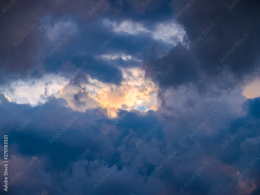 Obraz premium Heavy thunderclouds, illuminated from the inside by orange sunlight. Dramatic picture of nature.