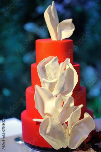 Traditional anniversary/wedding multi-layer cake. Beautiful delicious red sweet dessert decorated with white flowers
