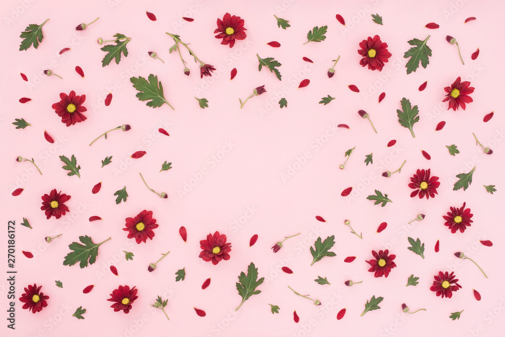Floral pattern made of red chrysanthemum, green leaves on pink background. Flat lay, top view. Valentines background. Pattern of flowers. Flowers pattern texture. Summer concept. Add your text.