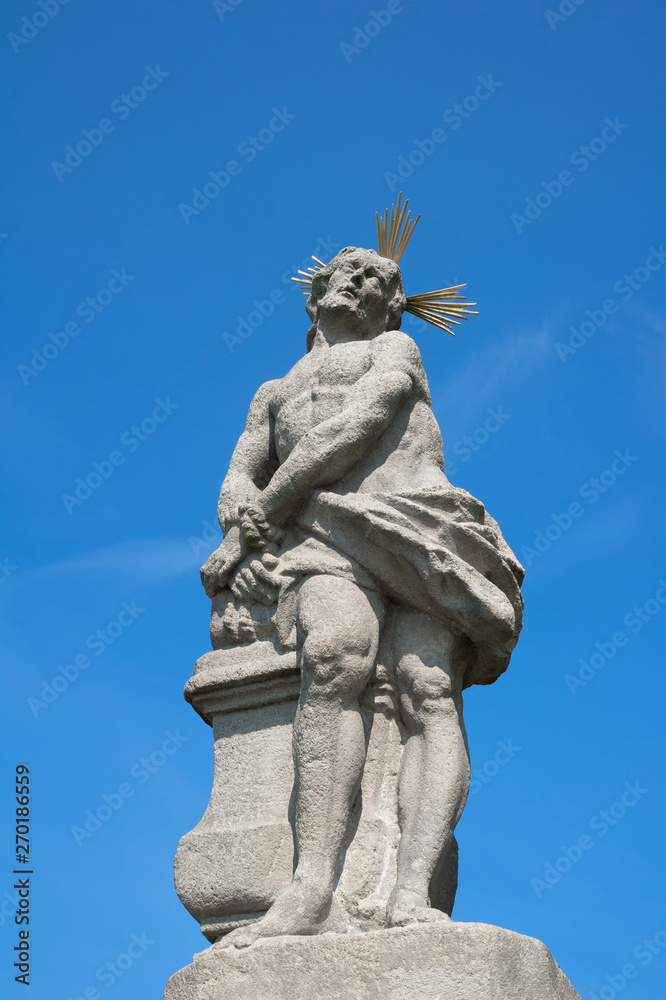 Statue and sculpture of suffering Jesus Christ, Olesna, Czech Republic / Czechia - historical lanmdark and monument from baroque era. Clear blue sky as copy space