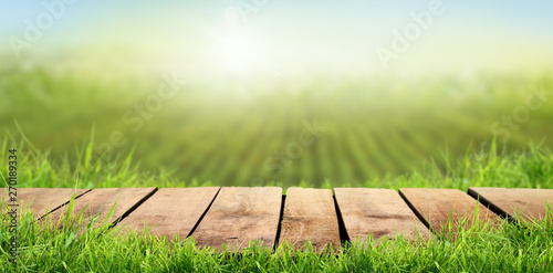 A wooden table with a sunny summers farmland background