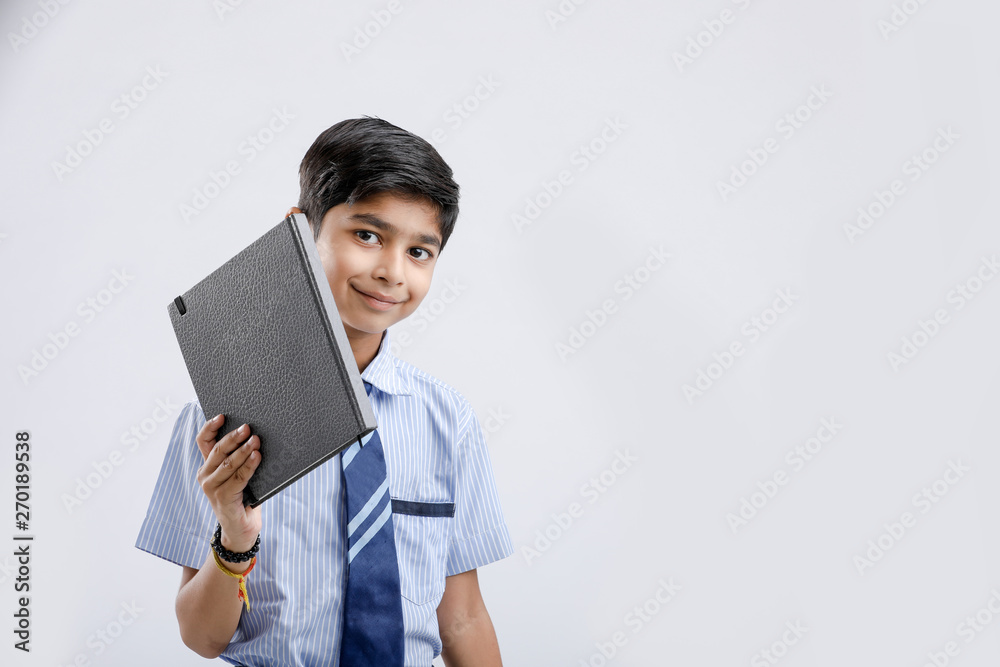 Cute little Indian/Asian school boy showing note book over white background Cute little Indian/Asian school boy showing note book over white background