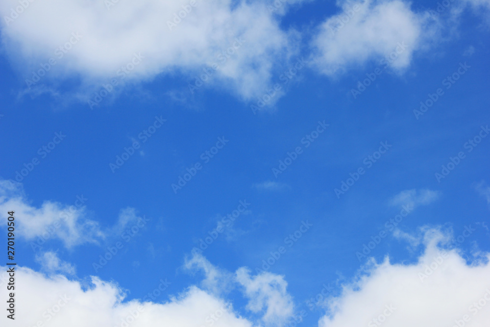 Blue sky background with clouds and empty space. Plain backdrop of