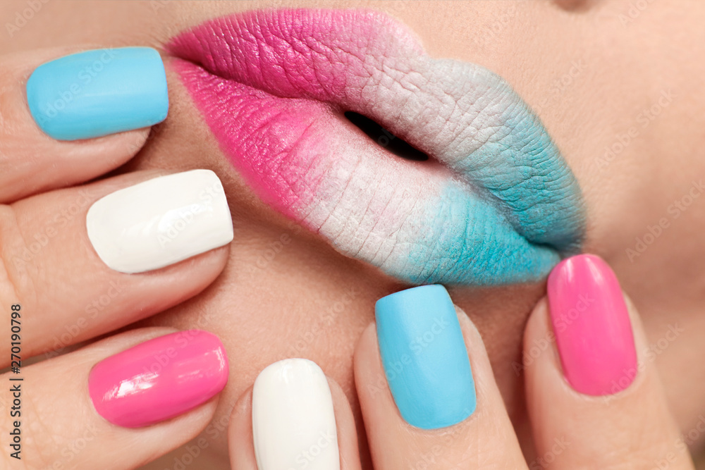 Multi-colored lip makeup and nail design with pink, blue matte and
