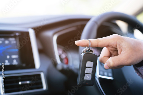 Car key, businessman hand holding over gives and show the car key interior the car. transportation concept 