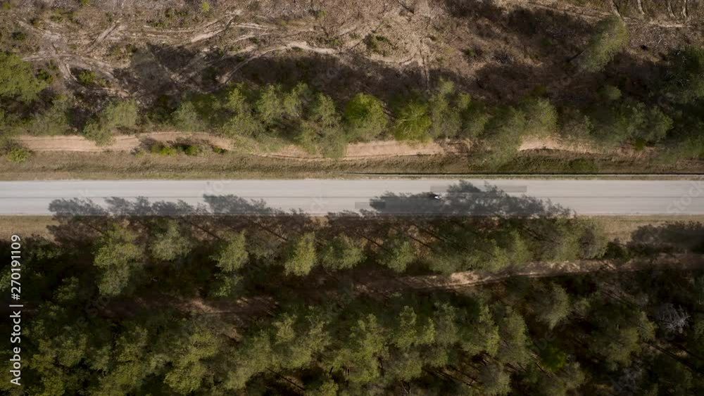 Aerial view of road in the forest and motorcycle driving on it. Aerial view of road in the forest and motorcycle driving on it.