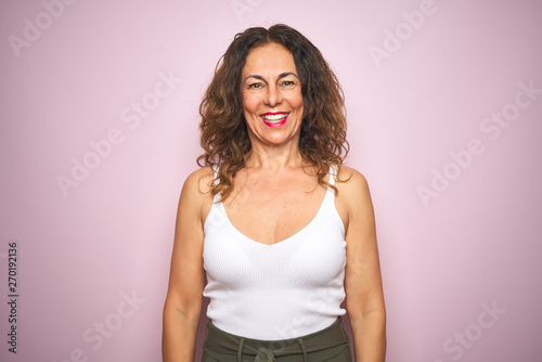 Middle age senior woman standing over pink isolated background with a happy and cool smile on face. Lucky person.