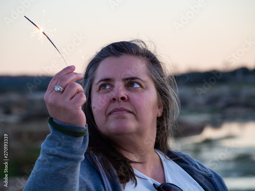 An adult curvy woman with a flare sizzled in his hand photo