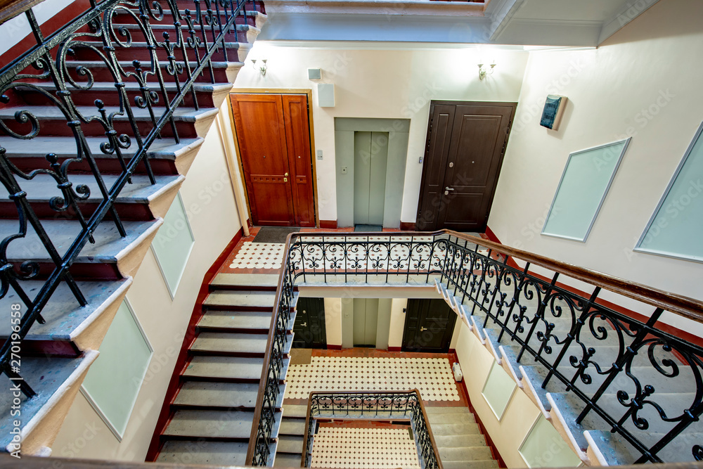 Obraz premium Staircase with forged railings on the railing in the old stairwell