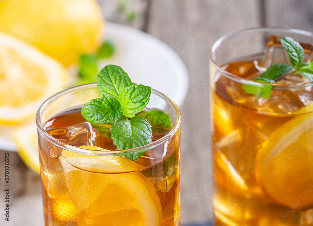 Fototapeta premium Glass of Refreshing Ice Tea With Lemon Slices and Mint Leaves