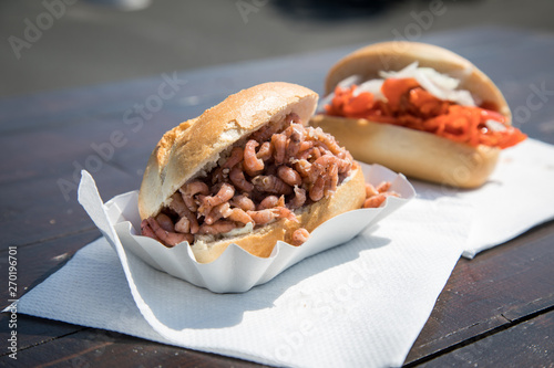 Fischbrötchen mit Nordseekrabben und Alaska Seelachs draußen auf Fischmarkt Holztisch als schneller regionaler Imbiss