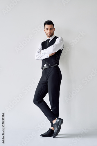 Full length portrait of handsome elegant man with crossed arms