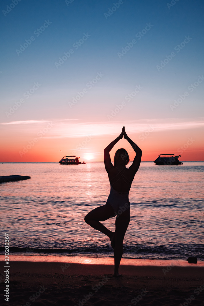 girl silhouette on the seashore. yoga and sports on the beach