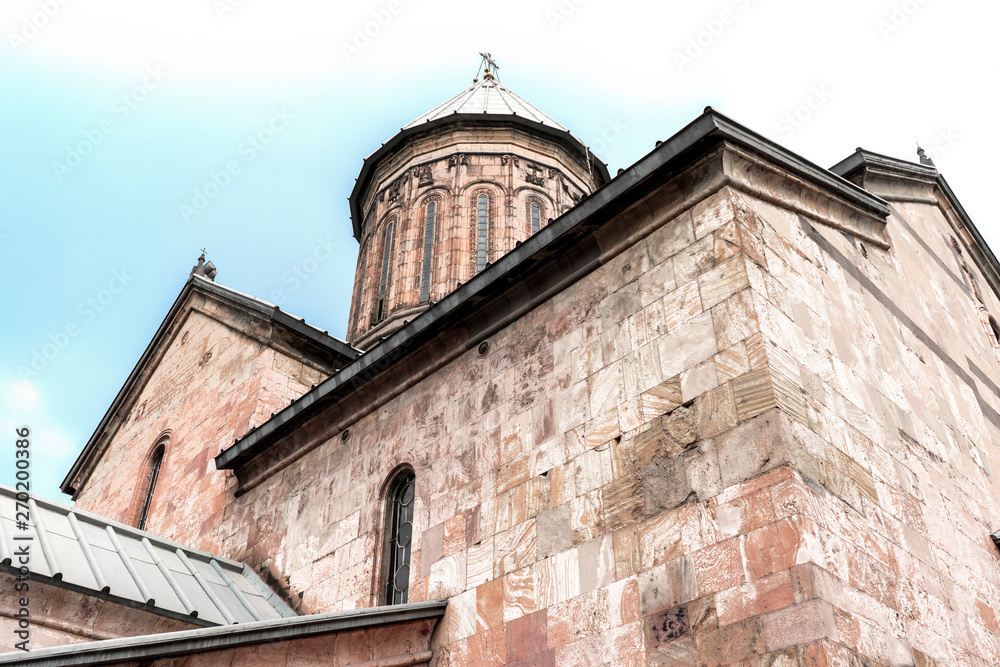 Fototapeta premium Medieval stone temple on the background of a blue sky, Georgia, May.2017