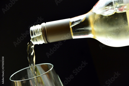 pouring white  wine from bottle