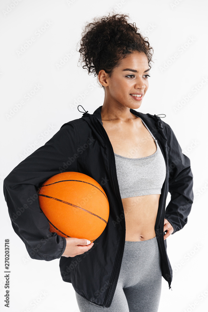 Beautful young amazing sports fitness african woman posing with basketball.