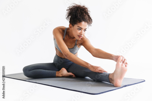 Amazing stronger sports fitness african woman make exercises isolated over white wall background.