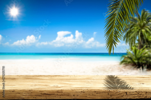 Fototapeta Naklejka Na Ścianę i Meble -  Wooden table background of free space and summer landscape of beach with palms and ocean. 