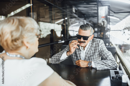 Attractive stylish senior man sniffs his favourite couban cigarette