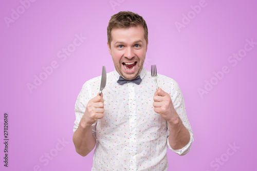 Man holding fork and knife on hand ready to eat photo