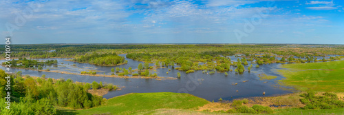 Panoramic photo. Horizontal landscape: the river flooded the valley. River and the field on a sunny summer day. Voroninsky National Park, Tambov Oblast, Russia.