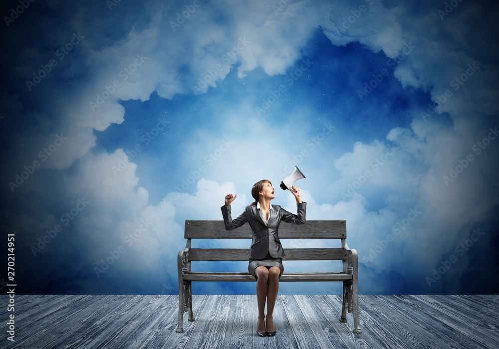 Business woman with megaphone on wooden bench Business woman with megaphone on wooden bench