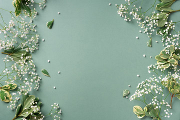 Small white gypsophila flowers on pastel green background. Women's Day, Mother's Day, Valentine's Day, Wedding concept. Flat lay. Top view. Copy space
